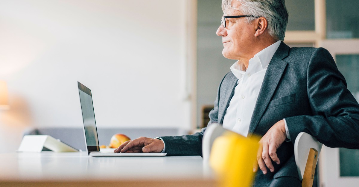 Photo of an older gentleman working at a laptop