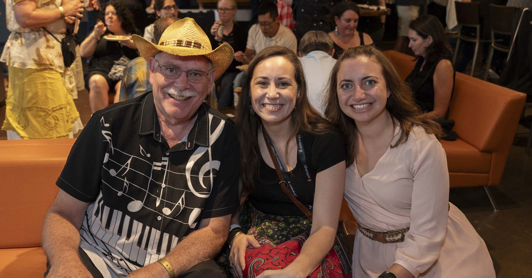 Three attendees on a couch, smiling for a picture